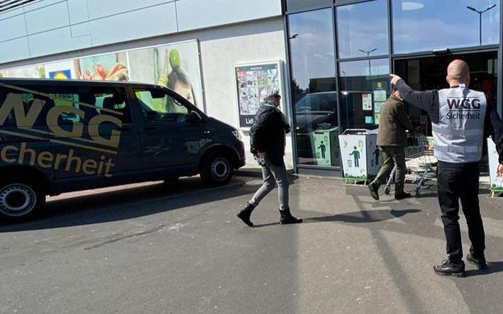 Mitarbeiter der WGG Sicherheit mit Einsatzfahrzeug am Eingang eines Supermarkts