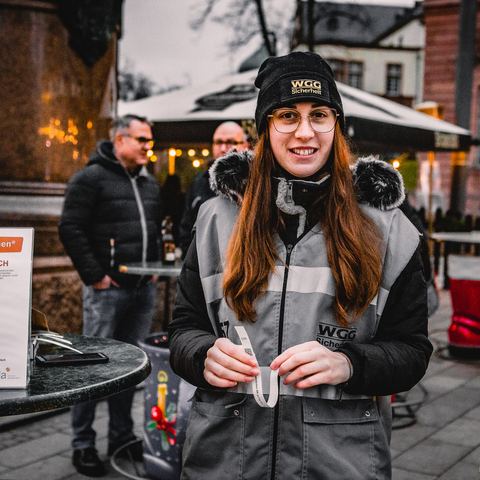 Lächelnde Mitarbeiterin der WGG Sicherheit auf dem Weihnachtsmarkt